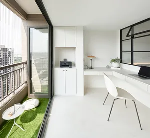 A minimalist office with white furniture, a large window, and green accents on the floor.