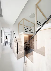 A modern minimalist living space featuring wooden stairs and glass walls.