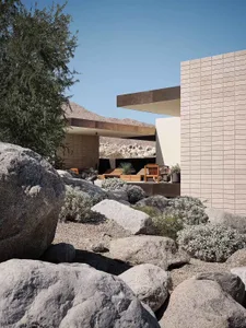 Modern house exterior featuring concrete, rock garden, and desert landscape.