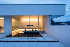 Modern minimalist residential patio featuring concrete and white gravel.