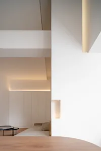 A minimalist living space with neutral-colored walls and furniture.