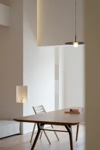 Modern office space featuring a wooden table and chairs against a white background.