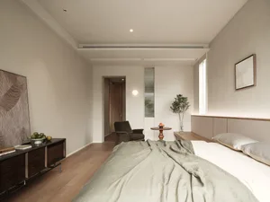 A modern minimalist bedroom featuring neutral tones and a single plant.