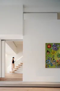 現代簡約室內空間，設有樓梯與色彩繽紛的抽象畫作。