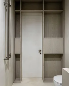 A minimalist bathroom with wooden cabinets and a white door.