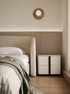 Modern minimalist bedroom with a wooden floor, a white bed with a light-colored blanket, and a white nightstand with marble t