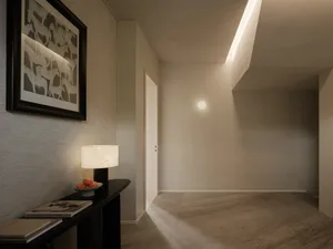 A minimalist entryway featuring modern lighting fixtures and a warm color palette.