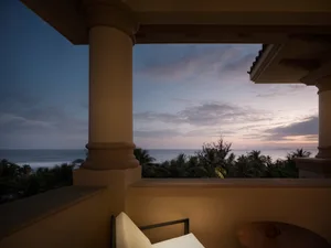 A residential patio overlooking the sea at sunset.