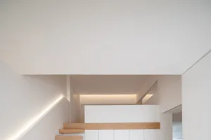 Modern minimalist interior with white walls and wooden accents.