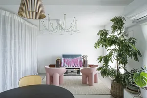 A modern living room featuring wooden furniture, concrete geometric shapes, and fabric seating.
