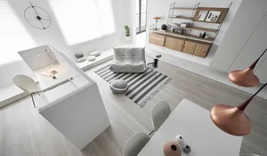A modern minimalist living room with a white interior, featuring white furniture, a gray sofa, and a striped rug, with a copp
