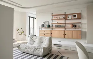 Modern minimalist living room featuring wood furniture and a striped rug.