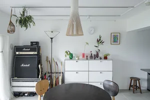 A modern music studio with minimalist design, featuring metallic elements, glass paneling, wooden furniture, and fabric acous