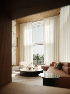 Modern living room with transparent curtains, leather sofa, and marble coffee table.