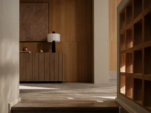 A modern interior with wooden furniture and a lamp, featuring a decorative wall panel.