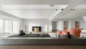 Modern living room with concrete seating, minimalist decor, and high ceilings.