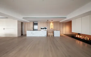 Modern residential kitchen with marble countertops, wooden cabinets, and a fireplace.