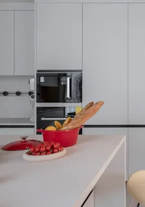 A modern, minimalist kitchen with grey concrete countertops and cabinets.