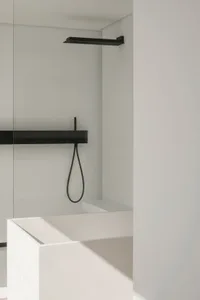 Modern bathroom featuring a glass shower enclosure and minimalist design.