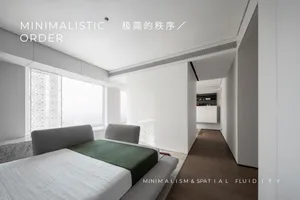 Modern minimalist bedroom featuring white walls, grey furniture, and a green throw blanket.