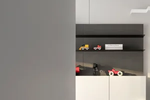 A modern interior with a toy display showcasing three colorful wooden cars and a book titled "A Glittering Dream"