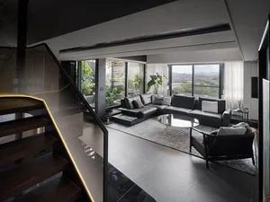 Contemporary living room featuring black and white color scheme with modern furniture and large windows.
