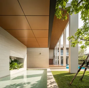 Modern architectural house with concrete walls and floor, featuring a pool and greenery.