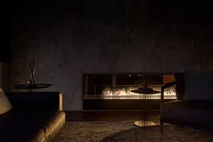 A minimalist living room featuring a marble fireplace, modern furniture, and textured carpet