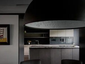 A modern kitchen with black marble countertops, minimalist cabinets, and sleek appliances.