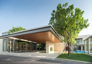 A modern residential building with a steel and glass facade, featuring a spacious outdoor patio and a swimming pool.