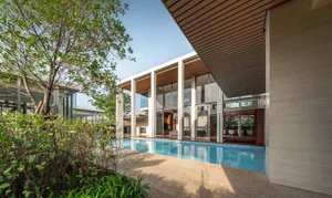 Modern house exterior with a concrete stone pond and pool.