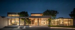 A modern residential architecture showcasing concrete, glass, and wooden elements.