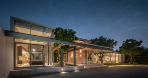A modern residential building with concrete exterior and illuminated features at night