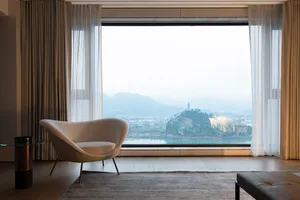 Modern living room with nylon curtains, white curtains, and flooring overlooking a scenic view.