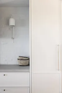 Modern minimalist interior design featuring concrete surfaces and sleek white cabinetry.