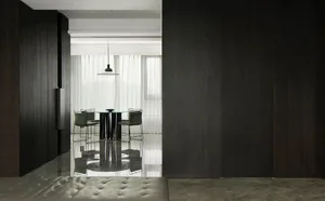 Modern dining room with a glass table and black furniture, featuring a minimalist design and clean lines.