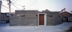 Modern minimalist building exterior made of brick, featuring clean lines and simple design.