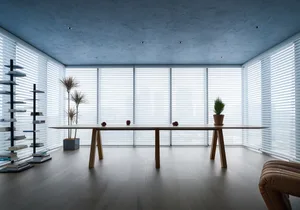 Minimalist office space featuring wooden furniture and glass walls.
