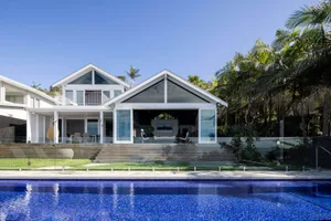 A modern house with a pool featuring glass and stone materials.