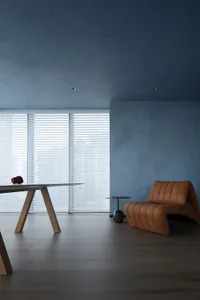 A modern living room featuring a cushioned seating area with a fabric upholstery and a minimalist table.