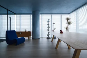 A modern minimalist live-work space with wood, glass, and concrete materials.
