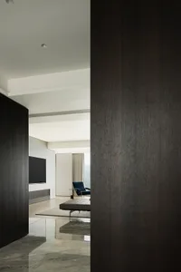 A modern, minimalist living room featuring metallic steel walls and marble flooring.