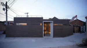 Modern residential home with brick exterior and large windows.