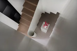 A modern staircase with wooden steps and a concrete handrail