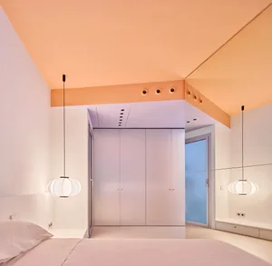 A minimalist bedroom with hardwood floors and white walls.