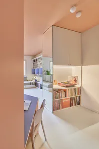 A minimalist living space featuring pastel-colored walls and furniture, with a focus on functionality and simplicity.