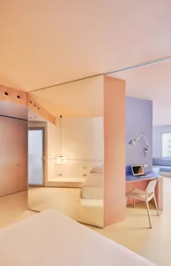 Minimalist bedroom with pink opaque glass divider and modern furniture.