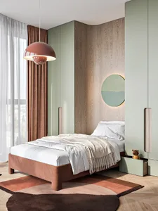 A modern bedroom with a single bed, wooden headboard, and warm-toned textiles.