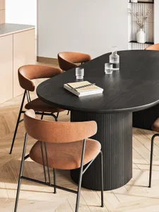 A modern dining room featuring a wooden table with orange upholstered chairs and a minimalist design.
