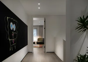 A modern home office with white walls and a blackboard on one wall, featuring a comfortable seating area and natural lighting